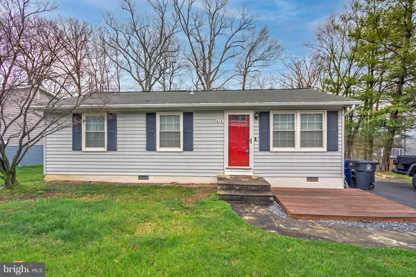 a front view of a house with a yard and trees