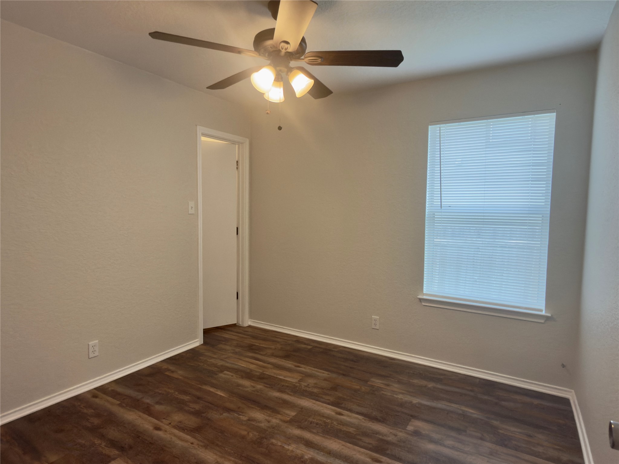 255 Myrtle Street Kyle, TX 78640 - Photo 16 of 31 Interior room featuring wood-finish flooring, light neutral wall paint, and white trim