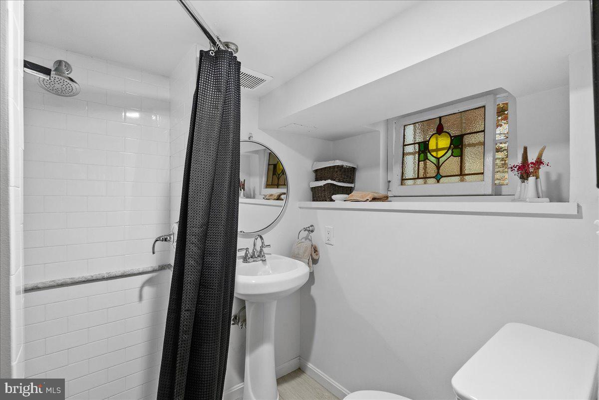 2815 Q Street Northwest Washington, DC 20007 - Photo 25 of 30 a bathroom with a sink mirror vanity and toilet