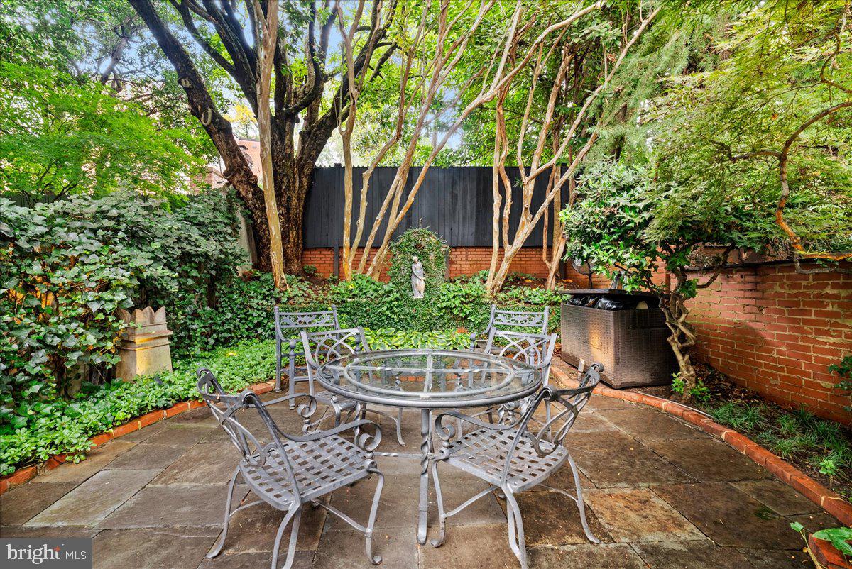 2815 Q Street Northwest Washington, DC 20007 - Photo 29 of 30 a view of a backyard with table and chairs potted plants and large tree
