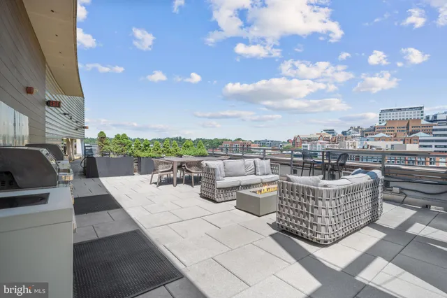 a view of a roof deck with couches and potted plants