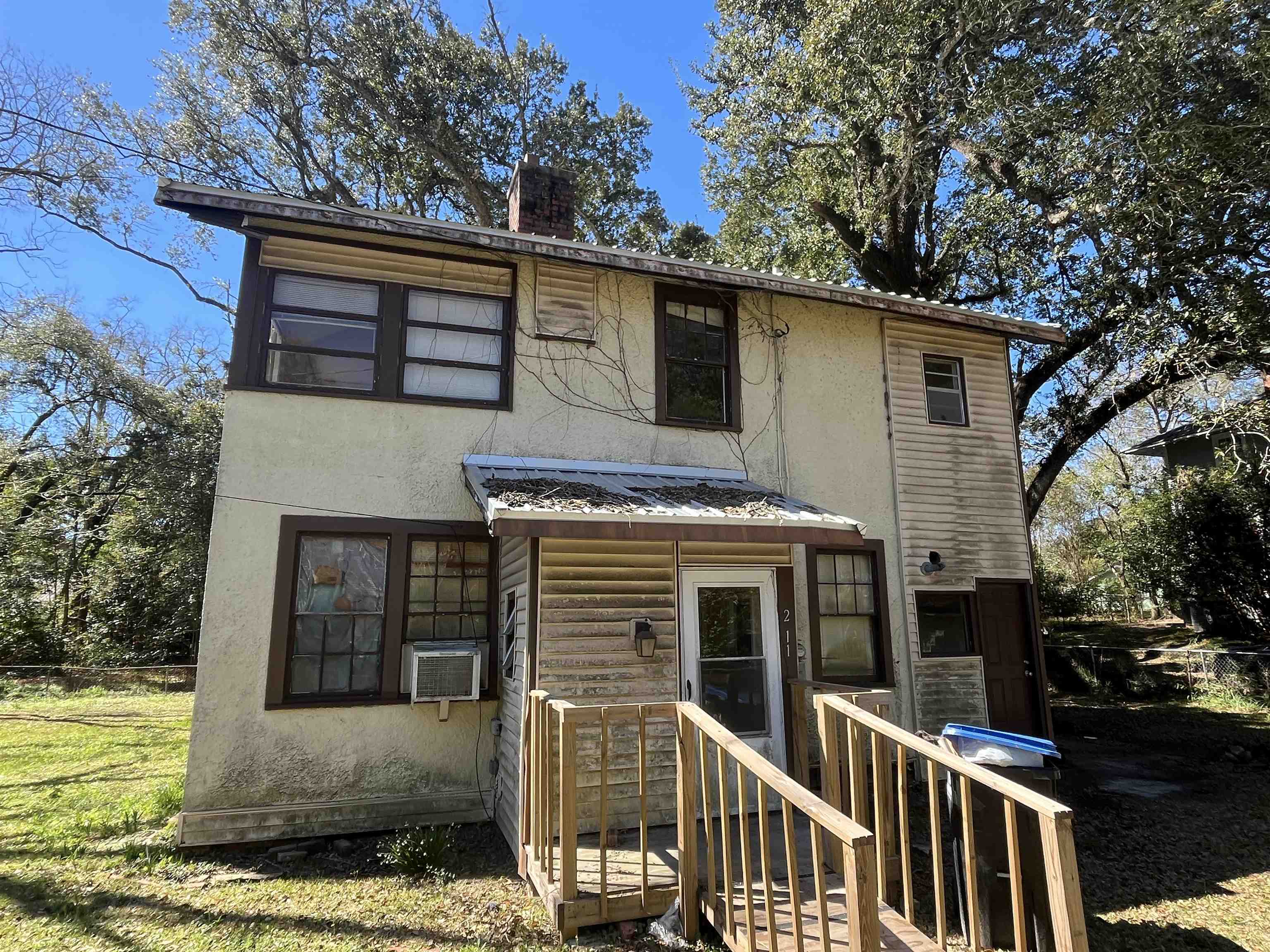211 4th Street Mobile, AL 36611 - Photo 2 of 34 View of front facade with a chimney, stucco siding, a metal roof, and cooling unit