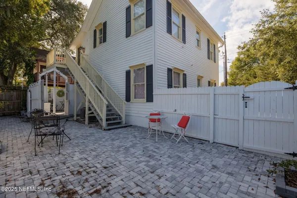 a backyard of a house with table and chairs