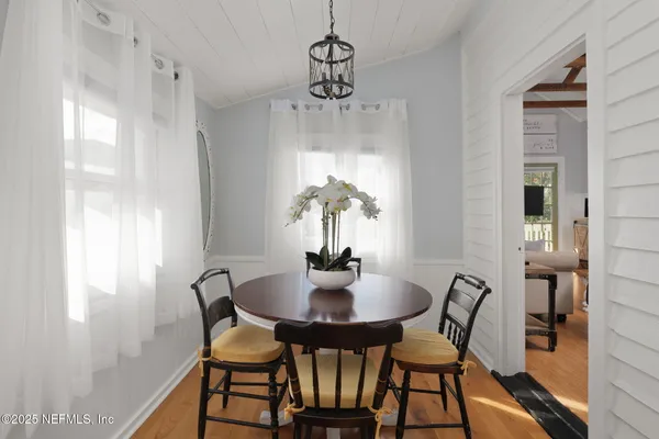 a dining room with furniture window and wooden floor