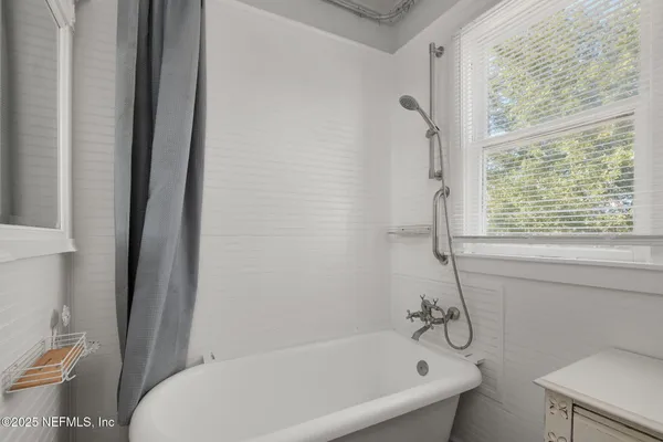a white bath tub sitting next to a toilet