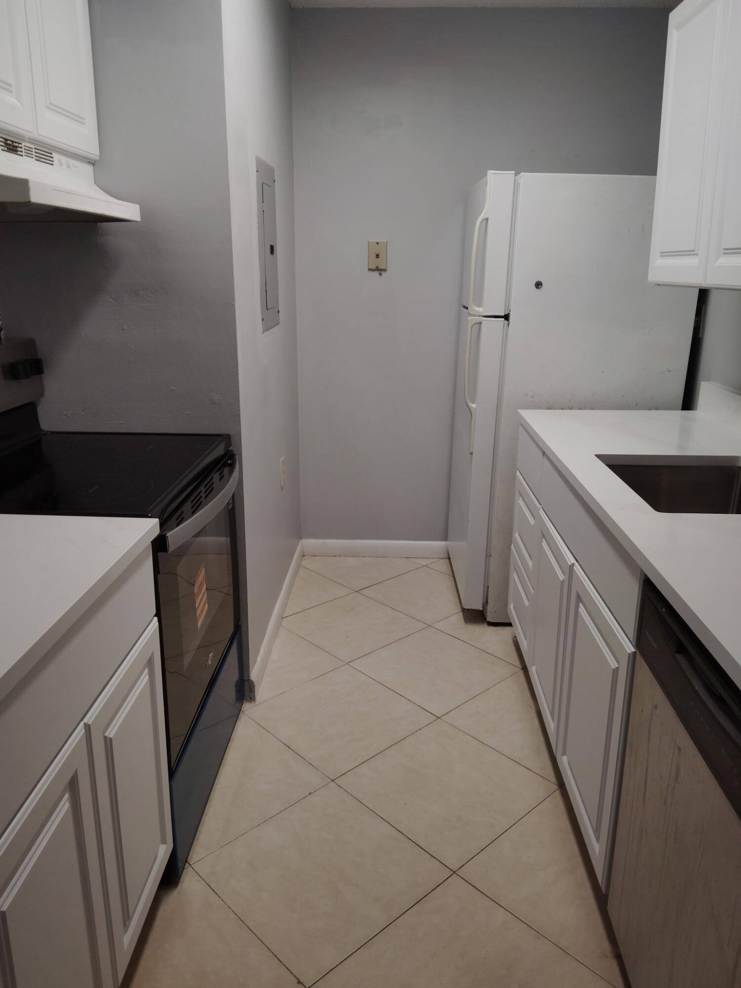 1140 Lake Victoria Drive, Unit M West Palm Beach, FL 33411 - Photo 5 of 8 a kitchen with a sink stove and refrigerator