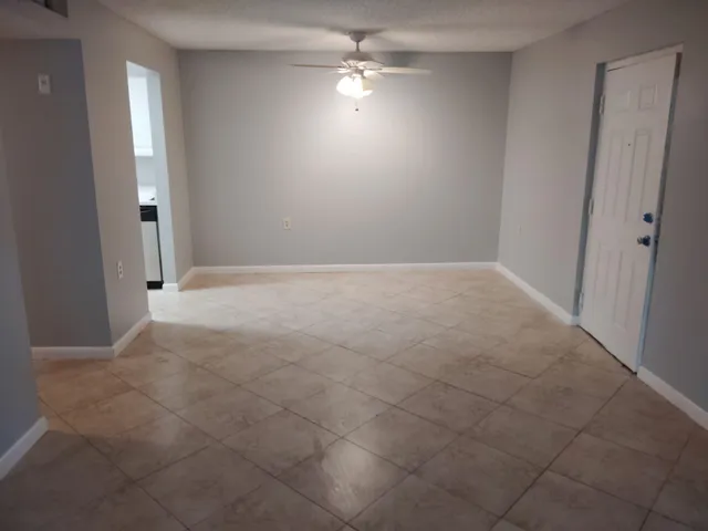 an empty room with fan and entrance