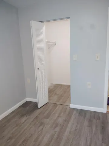 an empty room with wooden floor and mirror