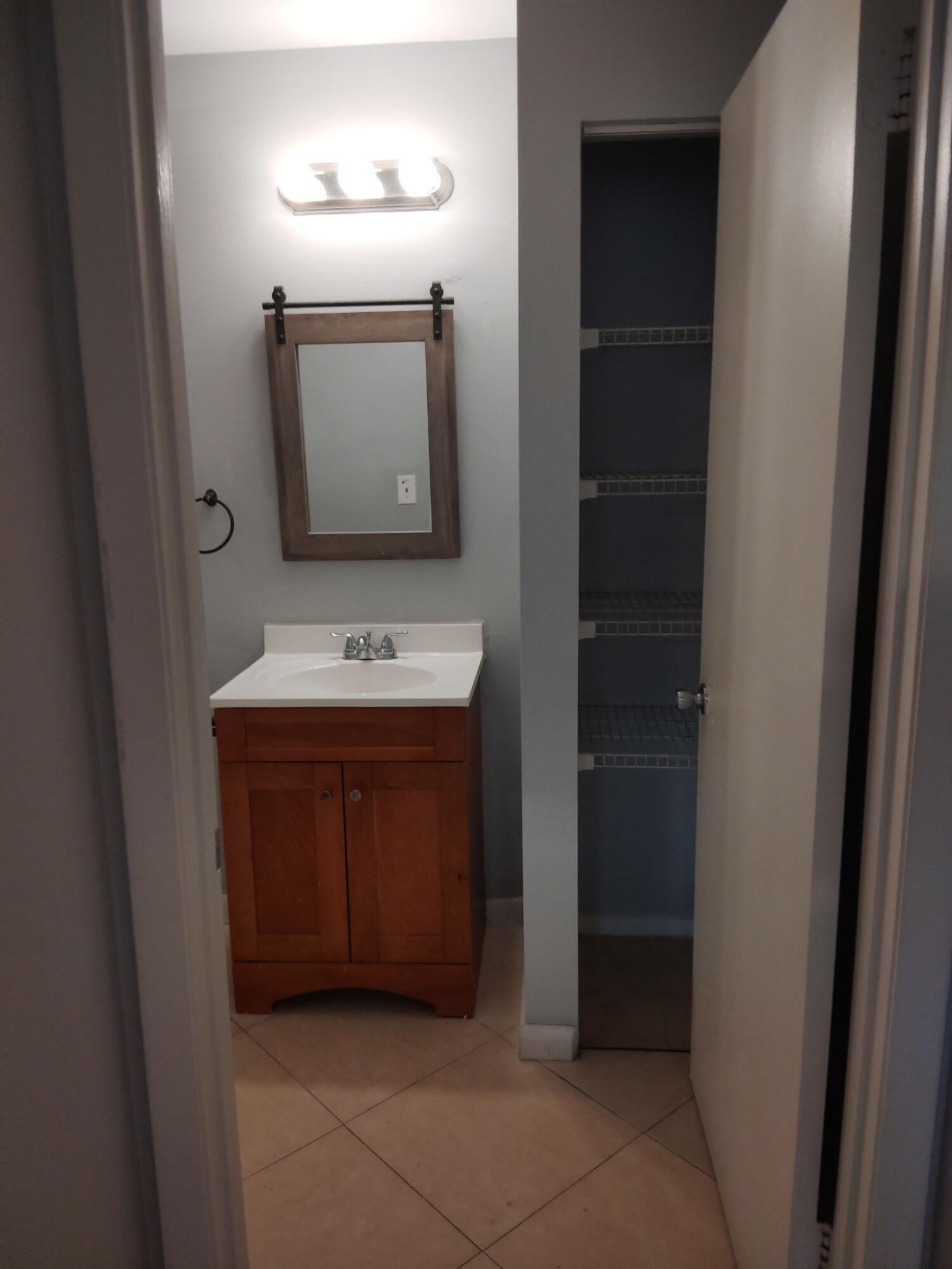 1140 Lake Victoria Drive, Unit M West Palm Beach, FL 33411 - Photo 8 of 8 a bathroom with a sink and a mirror