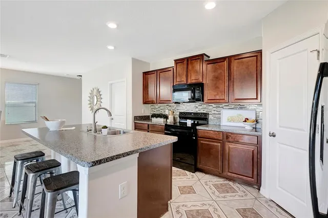 a kitchen with stainless steel appliances granite countertop a sink stove and microwave