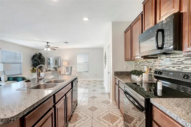 a kitchen with stainless steel appliances granite countertop a sink stove and microwave