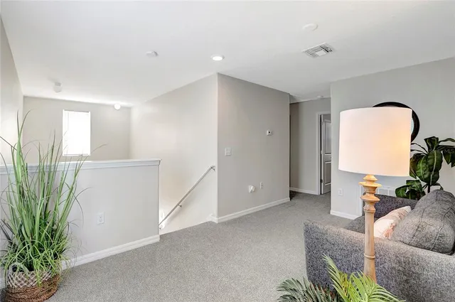 a living room with furniture a clock and a potted plant