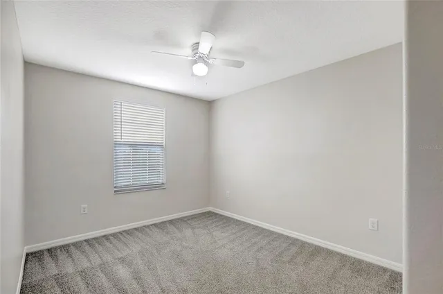 an empty room with a chandelier fan