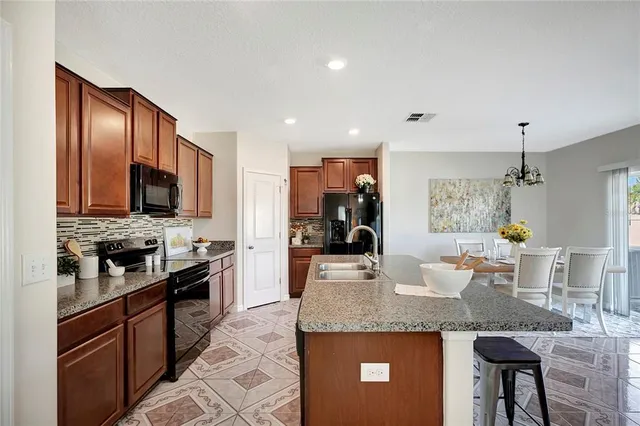 a kitchen with stainless steel appliances granite countertop a sink a stove and a refrigerator