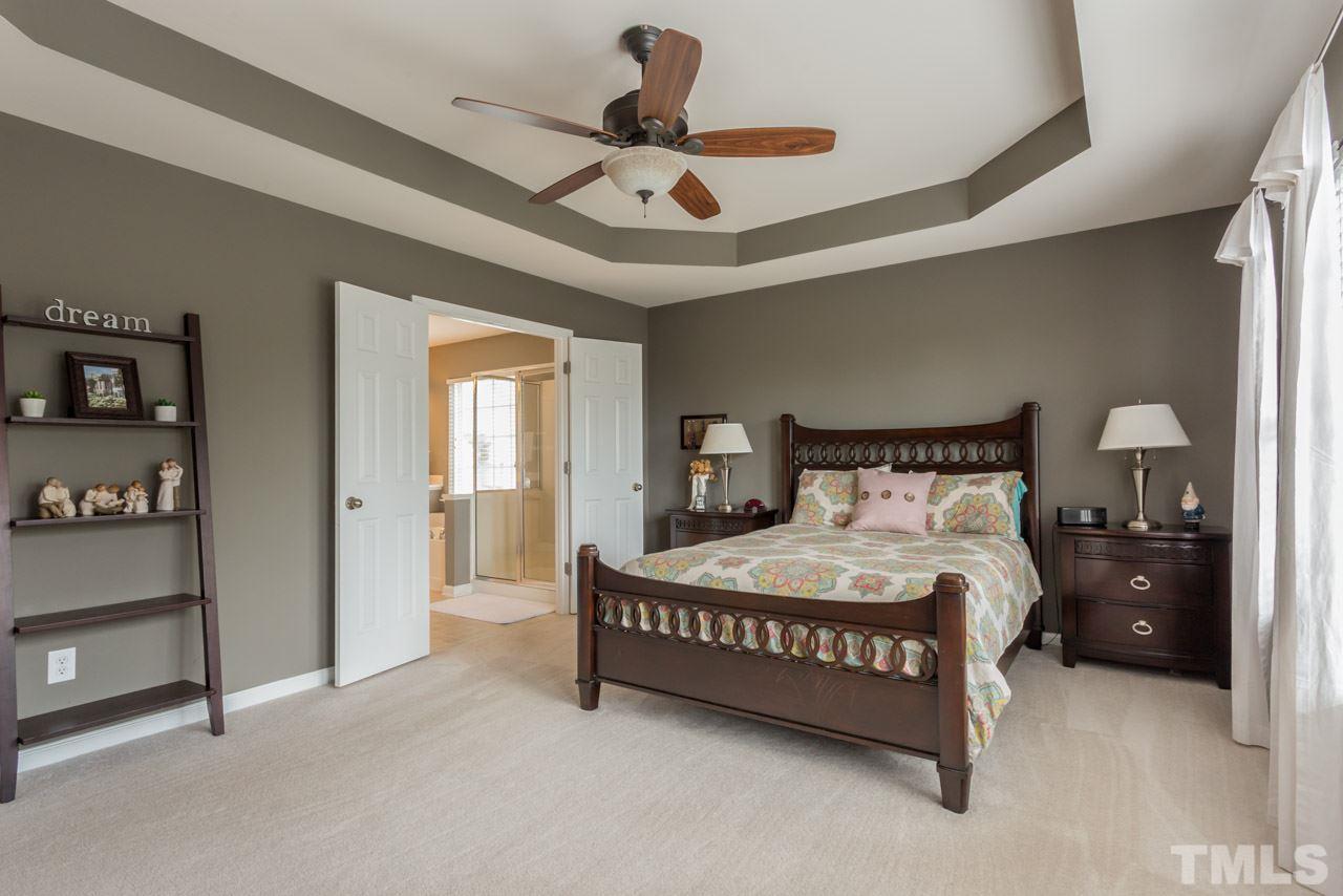 5331 Shaker Heights Lane Raleigh, NC 27613 - Photo 16 of 25 a bedroom with a bed and a chandelier