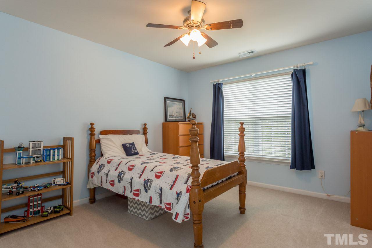 5331 Shaker Heights Lane Raleigh, NC 27613 - Photo 19 of 25 a bedroom with a bed and a chandelier
