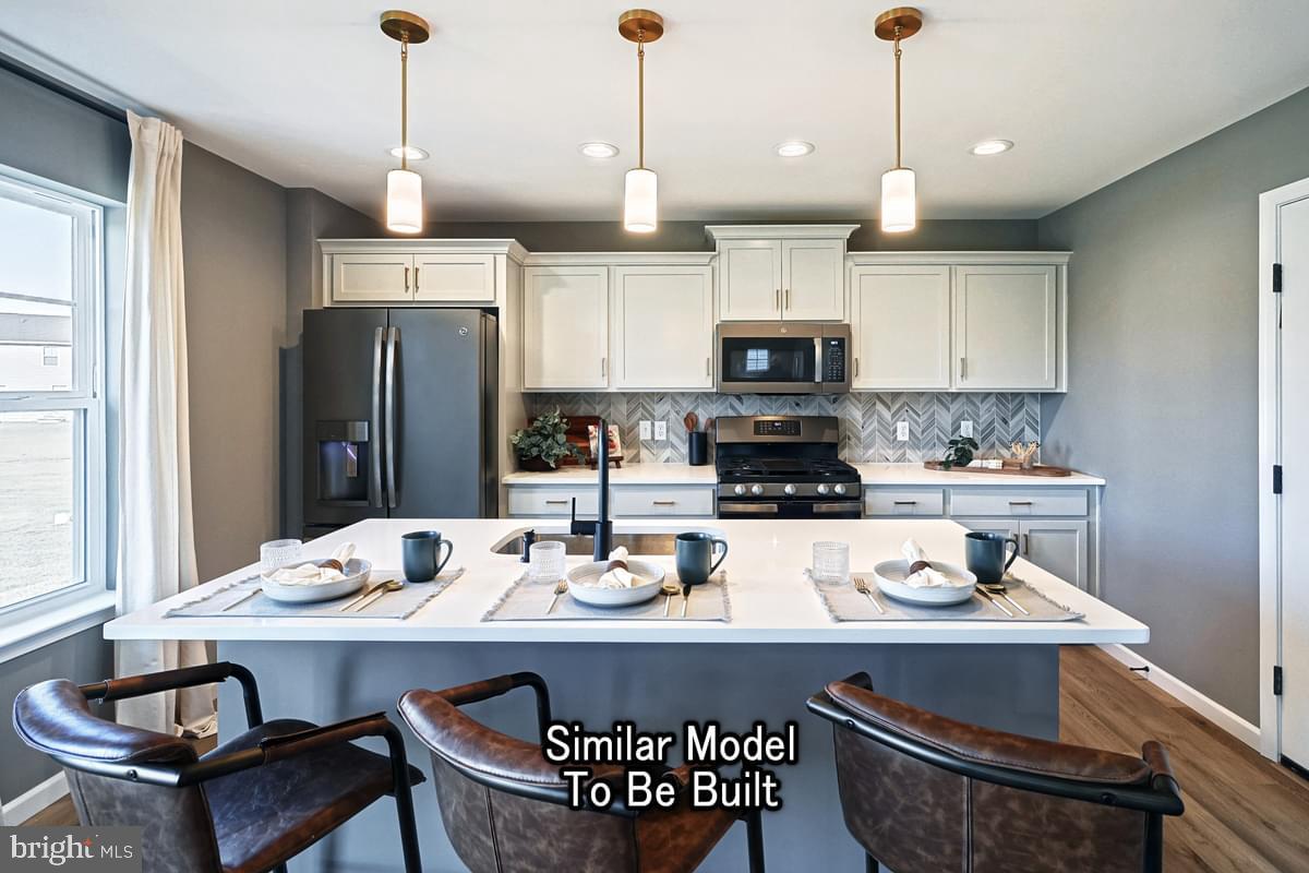 White Oak Plan At Hills Spring Grove, PA 17362 - Photo 16 of 42 a kitchen with a sink a stove and chairs