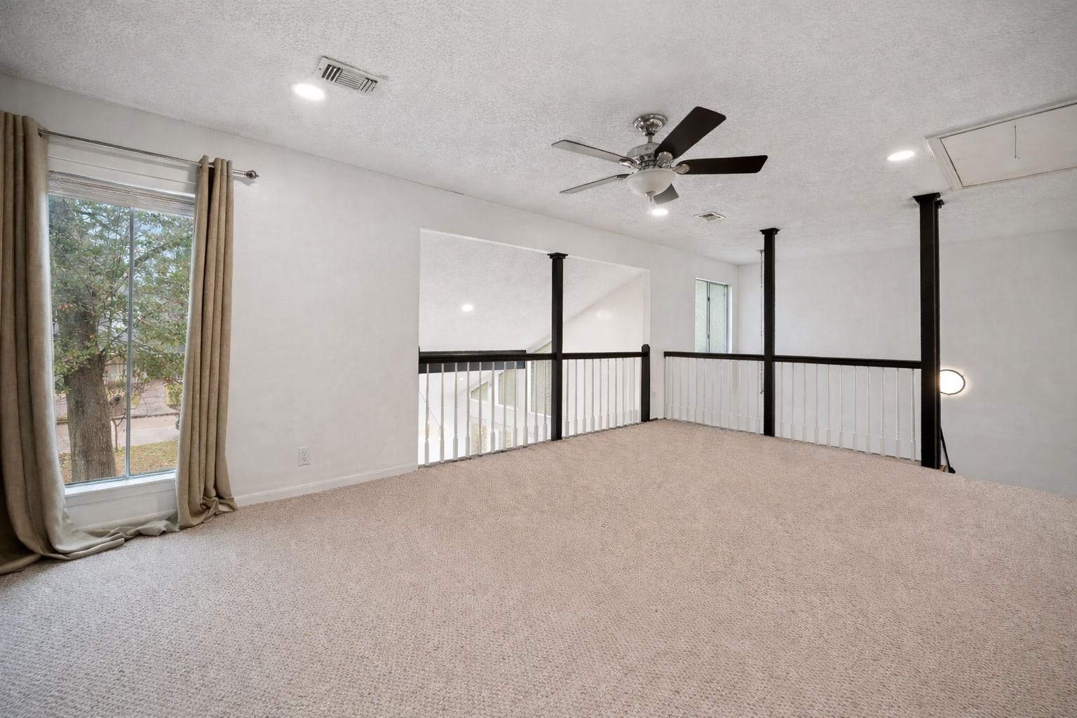 14907 Oak Bluff Court Houston, TX 77070 - Photo 17 of 19 Loft overlooks the dramatic two-story living area below.