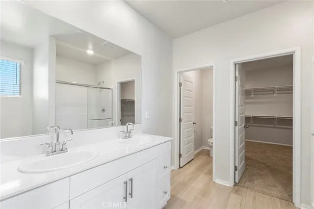 a bathroom with a double vanity sink mirror and shower