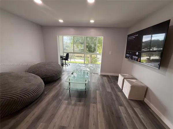 a living room with furniture and a floor to ceiling window