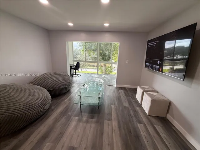 a living room with furniture and a floor to ceiling window