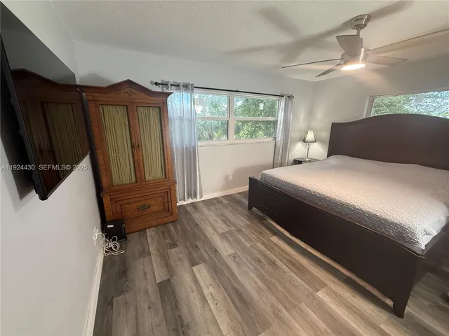 a bedroom with a bed a mirror and a window