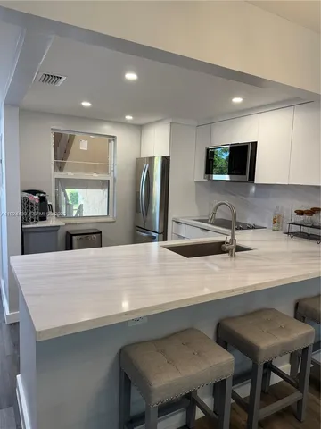 a large kitchen with a table and chairs
