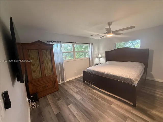 a bedroom with a bed closet and wooden floor
