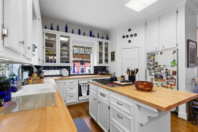 a kitchen with stainless steel appliances a stove a sink and white cabinets