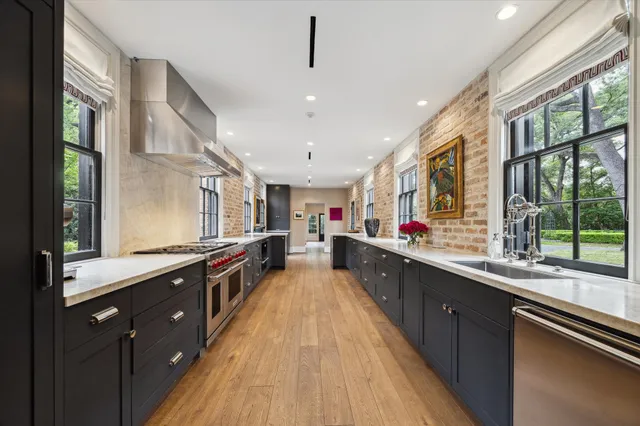 a large kitchen with stainless steel appliances a sink and counter space