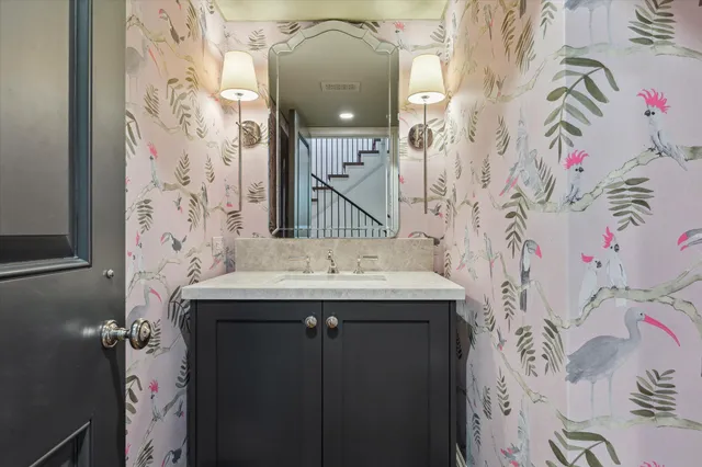 a bathroom with a sink and mirror with painted walls