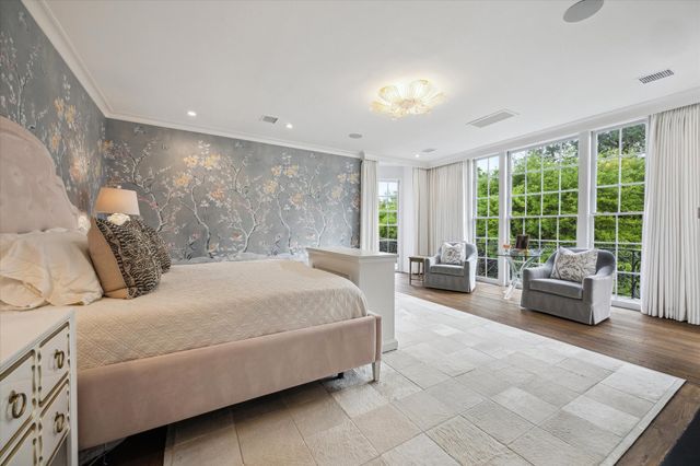 a bedroom with a bed and glass walk in closet