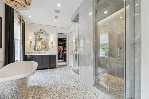 a bathroom with a tub sink mirror and shower