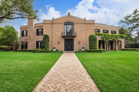 front view of a brick house with a yard
