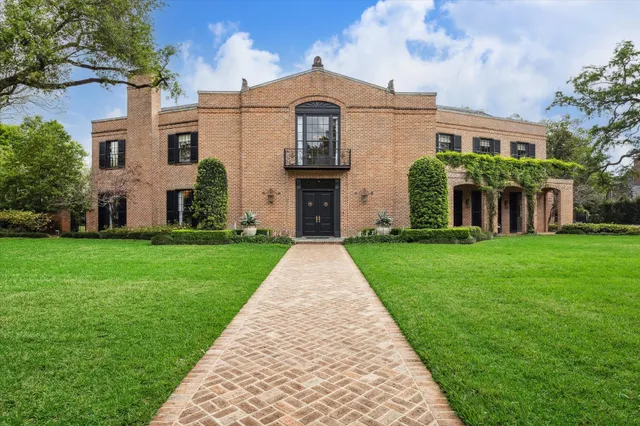 front view of a brick house with a yard