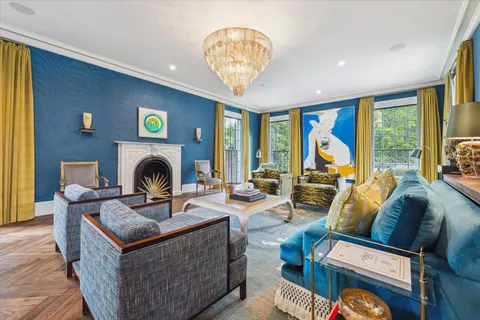 a living room with furniture a fireplace and a large window