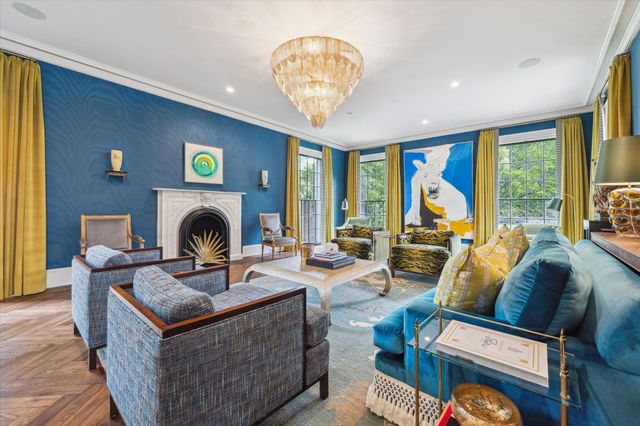 a living room with furniture a fireplace and a large window