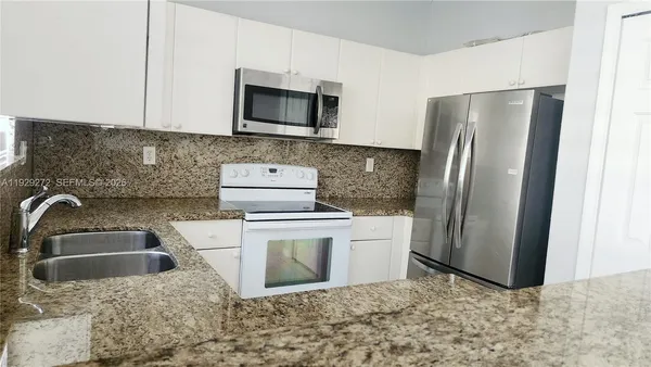 a kitchen with a refrigerator sink and microwave