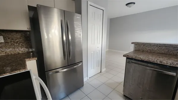 a metallic refrigerator freezer sitting in a kitchen