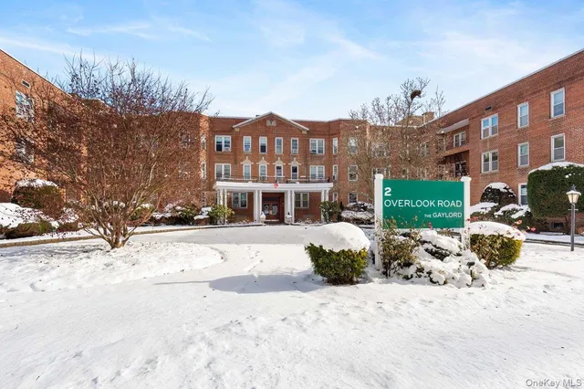 a view of a building with a yard covered in snow