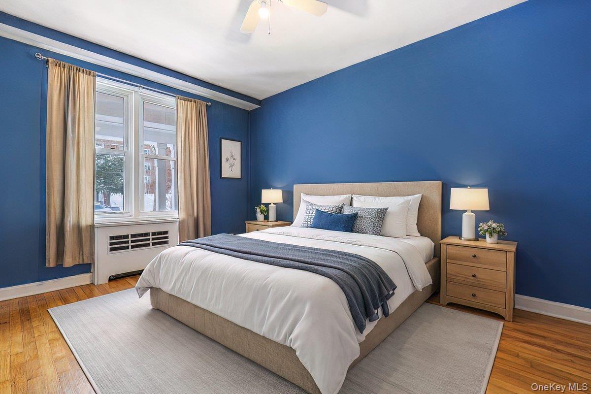 2 Overlook Road, Unit 1B7A White Plains, NY 10605 - Photo 6 of 18 a bedroom with a bed lamp and a large window with wooden floor