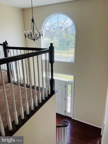 a view of staircase with railing and a window