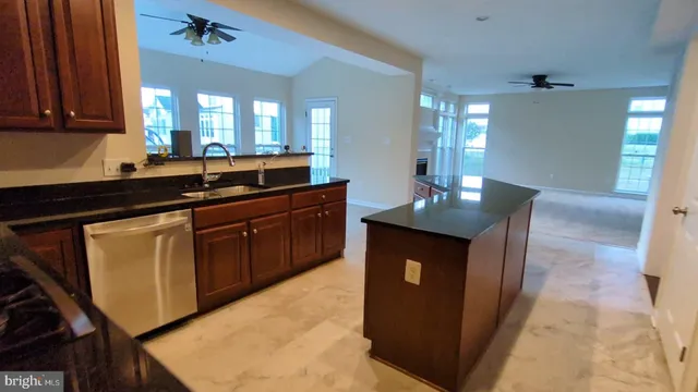 a kitchen with granite countertop a sink dishwasher stove and cabinets