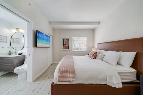 a bedroom with a bed a mirror and a window