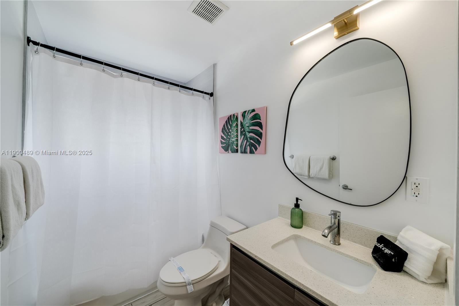 481 Northeast 29th Street, Unit 601 Miami, FL 33137 - Photo 18 of 23 a bathroom with a sink a mirror and a toilet