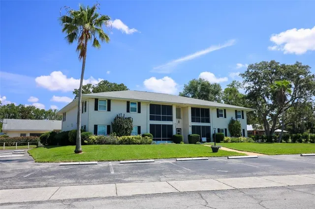 a view of a white house with a swimming pool and lawn chairs