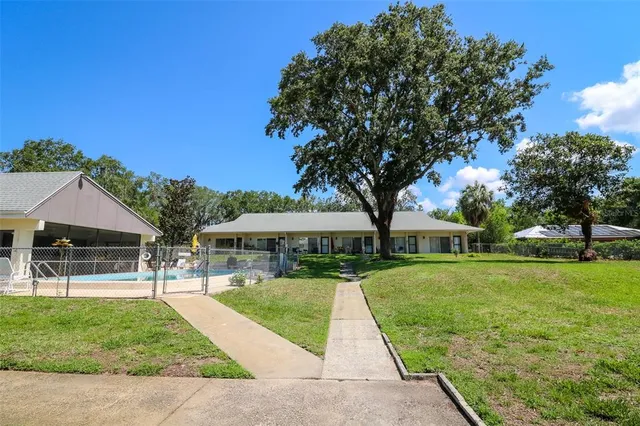 a view of a house with swimming pool and a yard