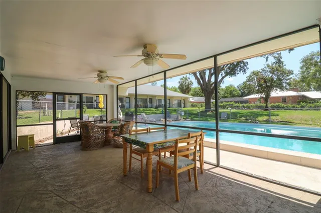 a view of a patio with table and chairs potted plants and a palm tree