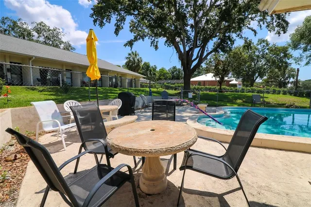 a view of a house with backyard and sitting area