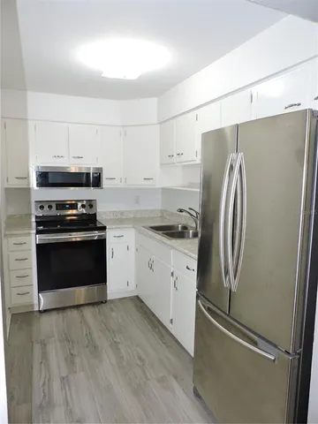 a kitchen with cabinets stainless steel appliances and a counter space